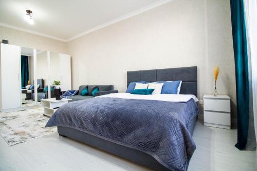 ein Schlafzimmer mit einem großen Bett und ein Wohnzimmer in der Unterkunft AB Apart Business 64305 in Astana