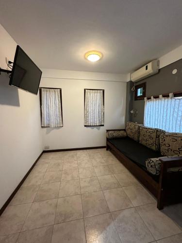 sala de estar con sofá y TV de pantalla plana en Complejo CHACARERO Departamentos en Balneario Mar Azul