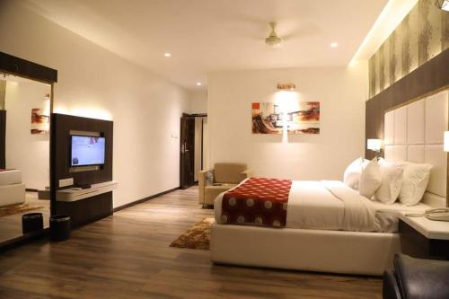 a hotel room with a bed and a television at The Four Seasons Recreation in Jālgaon