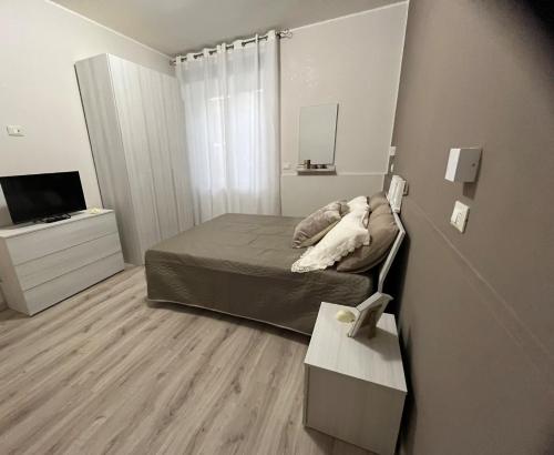 a small bedroom with a bed and a television at AMA B&B in Montesilvano