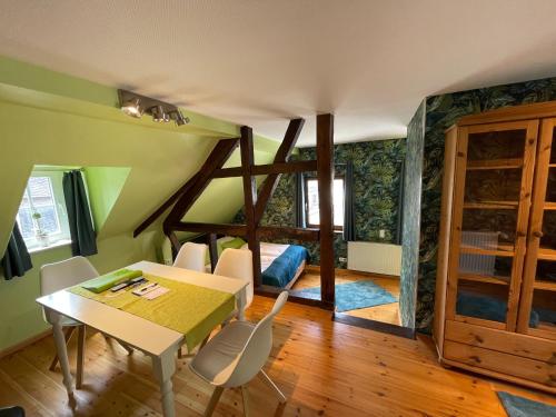 Hotel Garni Maaß في بروباخ: غرفة مع طاولة وكراسي وغرفة نوم