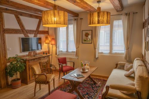 sala de estar con sofá y mesa en Chez l'Alsacien - Gîte authentique de charme classé 4 étoiles, en Barr