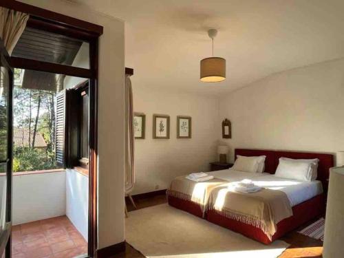 ein Schlafzimmer mit einem Bett und einem großen Fenster in der Unterkunft Casa de Santo António Moledo in Moledo
