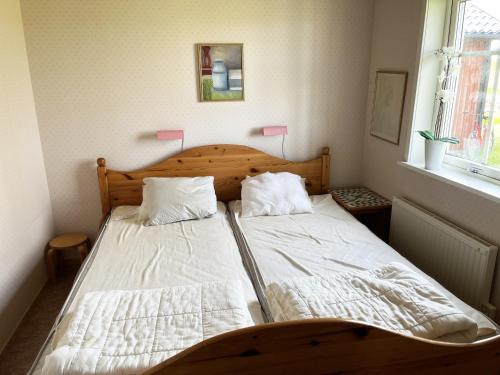 a bedroom with two beds and a window at Red cozy cottage with sea view in Mörbylånga