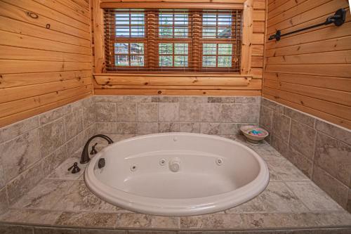 uma grande banheira branca num quarto com paredes de madeira em Family Sanity em McHenry