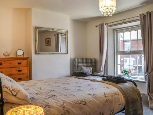 1 dormitorio con 1 cama, vestidor y ventana en Constable Cottage en Brampton