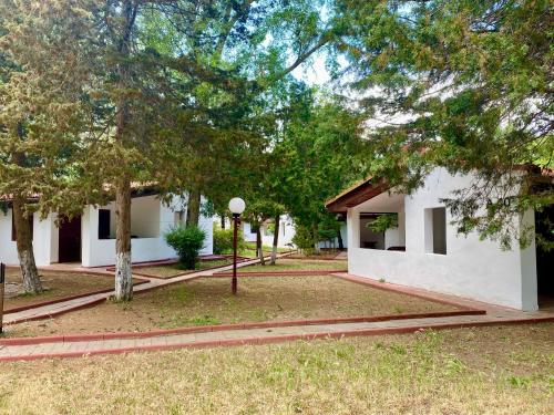 a white building with trees in front of it at Complex Holiday Neptun in Neptun