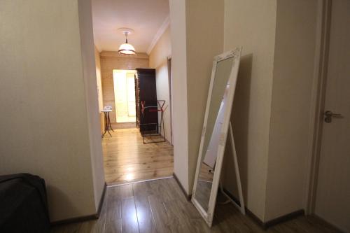 a hallway with a mirror next to a door at house by the river in Mestia