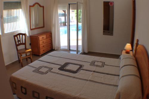カルプにあるMercedes - comfortable holiday accommodation in Calpeのベッドルーム1室(ベッド1台、ドレッサー付)、ベッドルーム1室(プール付)
