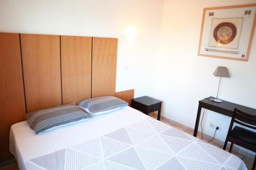 une chambre avec un grand lit avec une tête de lit en bois dans l'établissement Appartement 223 supérieur - LES SUITES DE ROBINSON - Résidence avec piscine en bord de Siagne, à Mandelieu-La-Napoule, à Mandelieu-la-Napoule