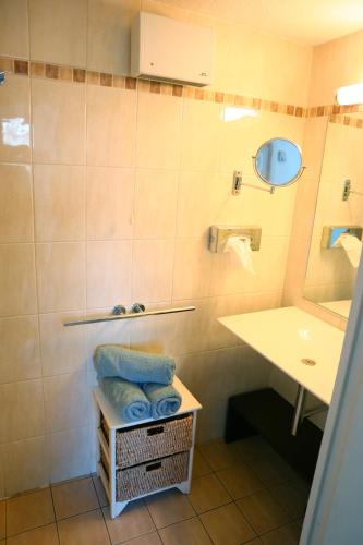 une salle de bain avec un lavabo et un miroir dans l'établissement Appartement 223 supérieur - LES SUITES DE ROBINSON - Résidence avec piscine en bord de Siagne, à Mandelieu-La-Napoule, à Mandelieu-la-Napoule