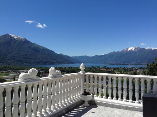 a white fence with a view of the water and mountains at Ferienhaus Patrizia with a fantastic view of Lake Maggiore and the pool in Gordola