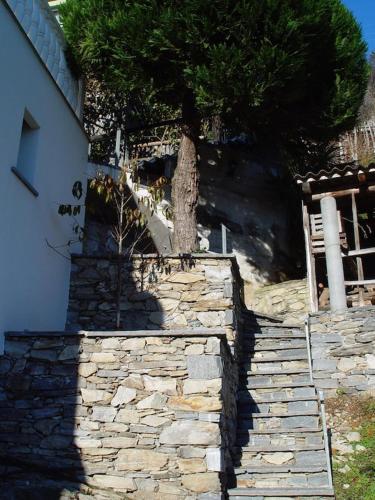 a stone retaining wall next to a house at Ferienhaus Patrizia with a fantastic view of Lake Maggiore and the pool in Gordola