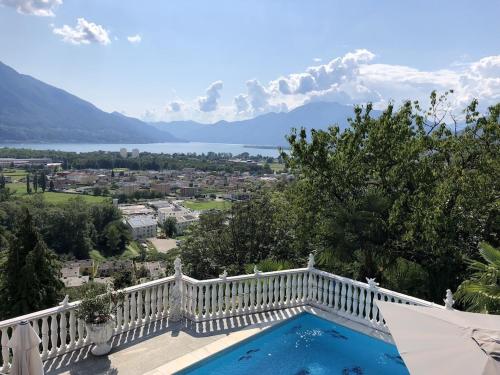 a swimming pool on a balcony with a view of the mountains at Ferienhaus Patrizia with a fantastic view of Lake Maggiore and the pool in Gordola