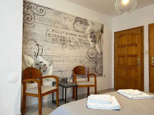 two chairs and a table in a room with a wall at Panorama Chantall-izby,apartmány s výhľadom na more in Ravda