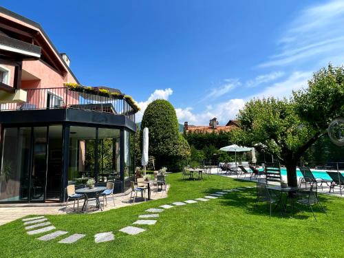 a yard with tables and chairs and a pool at Villa Costantina with heated POOL in Cannobio