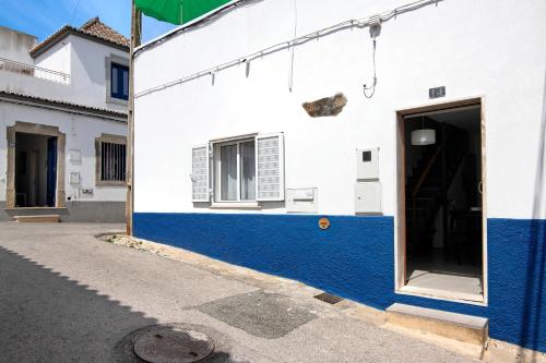 a white and blue building with a door at Casa da Avó Edite in Tavira