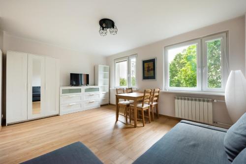 a kitchen and dining room with a table and chairs at Ochota Standard Apartment in Warsaw