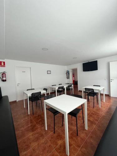 a group of tables and chairs in a room at ALBERGUE CASTELOS VILALBA in Villalba