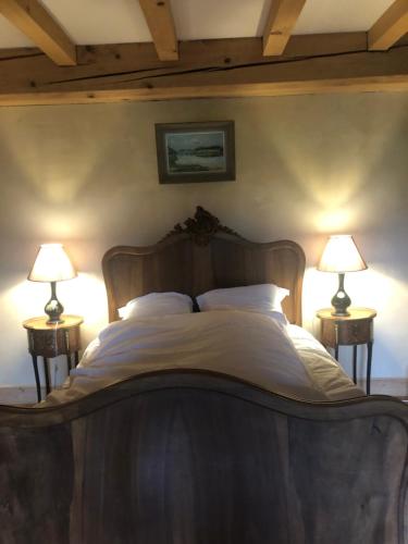 une chambre avec un grand lit avec deux lampes dans l'établissement L’ABSINTHE, à Bannans