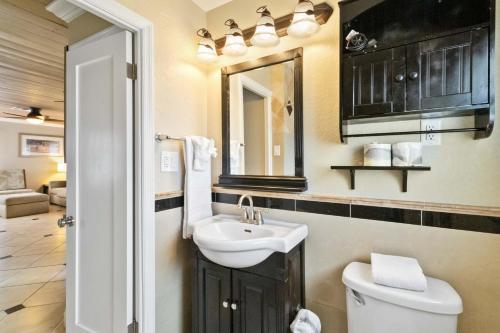 uma casa de banho com um lavatório, um WC e um espelho. em 113 Surf Song Resort em St Pete Beach