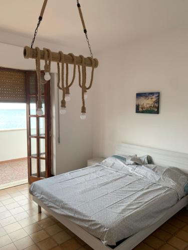 a bedroom with a bed and a chandelier at Nontiscordardimé Apt in Torre a Mare