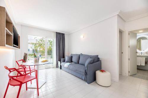 a living room with a blue couch and a table at Hotel Vibra Isola - Adults only in Playa d'en Bossa