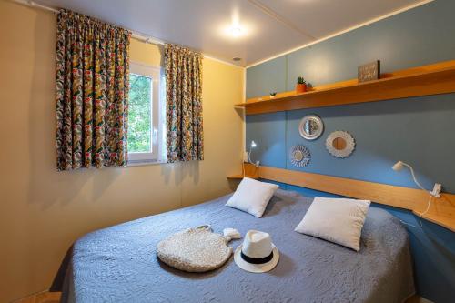 um quarto com uma cama com dois chapéus em La Doucette, mobil-home climatisé au cœur du vignoble et à 50m de la mer em Hyères