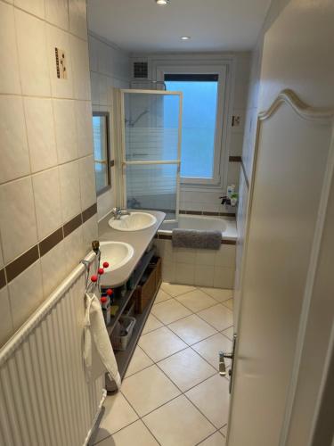 een badkamer met een wastafel, een bad en een spiegel bij Le mûrier - 2 chambres chez l'habitant in Rhut