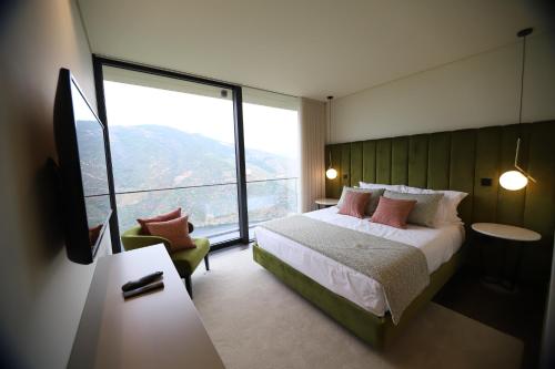 a bedroom with a bed and a large window at Quinta Vale de Lobos Douro in Folgosa