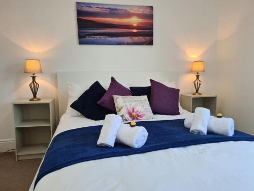 a bedroom with a bed with purple and white pillows at Cosy Cottage for work or leisure, RD&E 20min walk, easy access to city centre in Exeter
