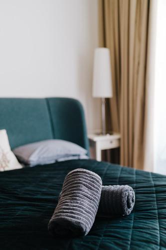 a towel laying on top of a bed at Butique Apartman in Balatonlelle