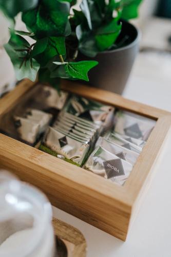 a wooden box filled with food on a table with a plant at Butique Apartman in Balatonlelle