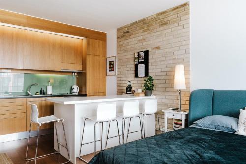 a kitchen and a bedroom with a bed and a counter at Butique Apartman in Balatonlelle