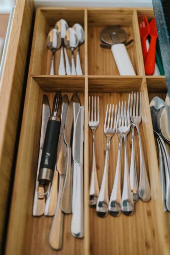 a wooden drawer with utensils in it at Butique Apartman in Balatonlelle