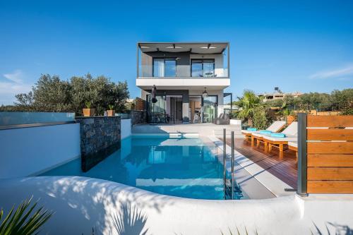 uma villa com uma piscina e uma casa em Aida Luxury Villas em Analipsi