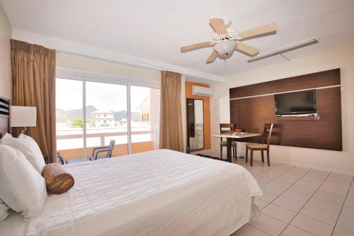 um quarto de hotel com uma cama e uma televisão de ecrã plano em Horizon View Beach Hotel em Philipsburg