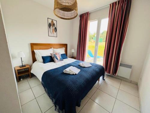1 dormitorio con 1 cama con 2 toallas en Maison résidence Odalys à Morgat en bretagne sur la presqu'île de crozon ,piscine chauffée, située à 800 m de la mer, en Crozon