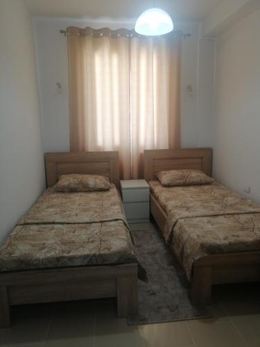 Duas camas sentadas uma ao lado da outra num quarto em Dizara Apartman's em Ulcinj
