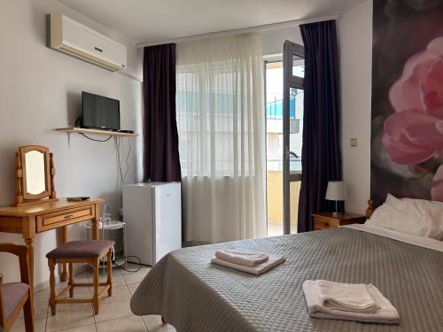 a bedroom with a bed and a desk and a window at Panorama Chantall-izby,apartmány s výhľadom na more in Ravda
