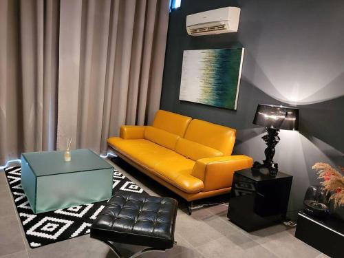 Empire Damansara Designer Soho Karaoke & Netflix في بيتالينغ جايا: غرفة معيشة مع أريكة صفراء وطاولة