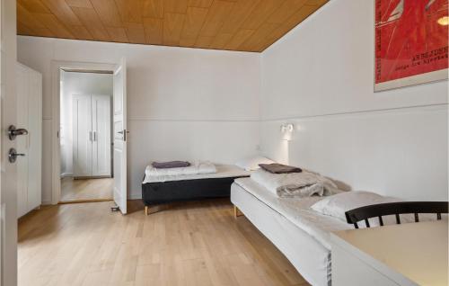 a white room with two beds and a table at 2 Bedroom Awesome Apartment In Hejls in Hejls