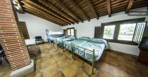 Zimmer mit 4 Betten und einem TV. in der Unterkunft El Abejal in Ciudad-Rodrigo