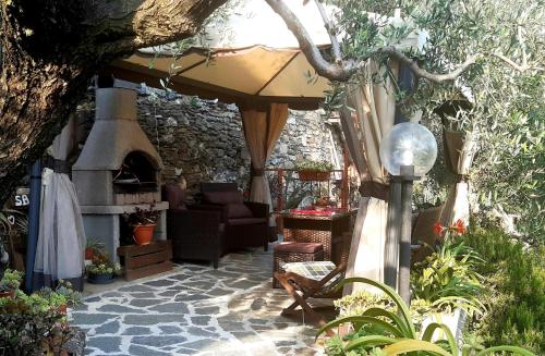 an outdoor patio with an umbrella and a fireplace at Agriturismo I Pipetta in Levanto