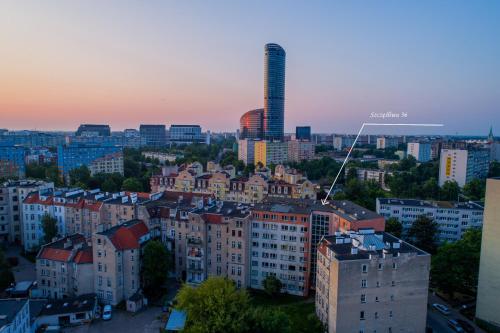 a view of a city at sunset with buildings at Studio Szczęśliwa 36 przy SkyTower! in Wrocław