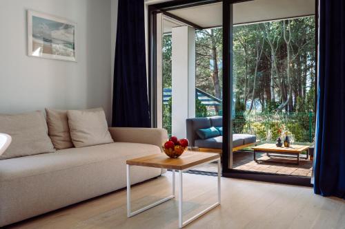 a living room with a couch and a table at Apartamenty Wydma & Las BlueApart in Jastarnia