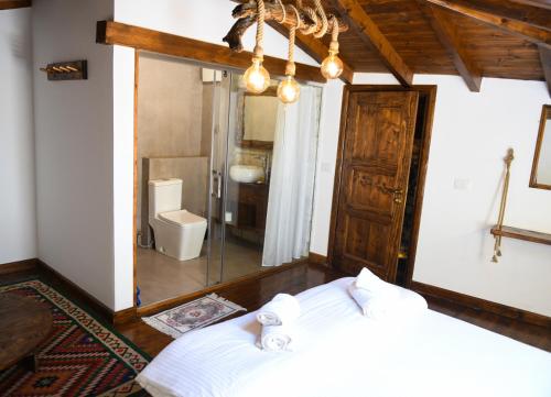 a bedroom with a bed and a bathroom with a shower at Anhel Hotel in Berat