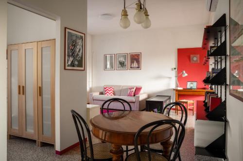 a living room with a table and chairs and a couch at Accomodo Milano - MIB13 Bivano Navigli in Milan
