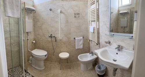 e bagno con servizi igienici, lavandino e doccia. di Hotel Morolli a Rimini