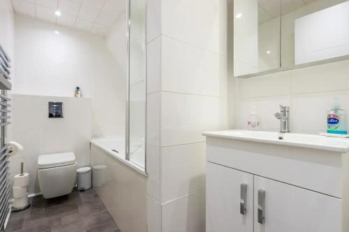 Beautiful 1 Bedroom penthouse Flat في لندن: حمام ابيض مع مرحاض ومغسلة